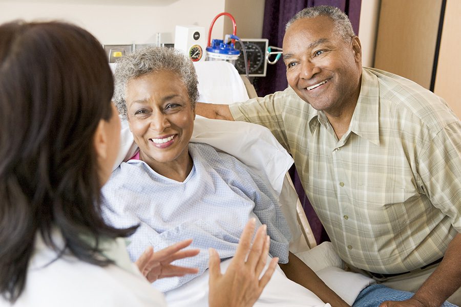 Hospital Indemnity Plans - Doctor with Patient and Her Husband in a Hospital Room